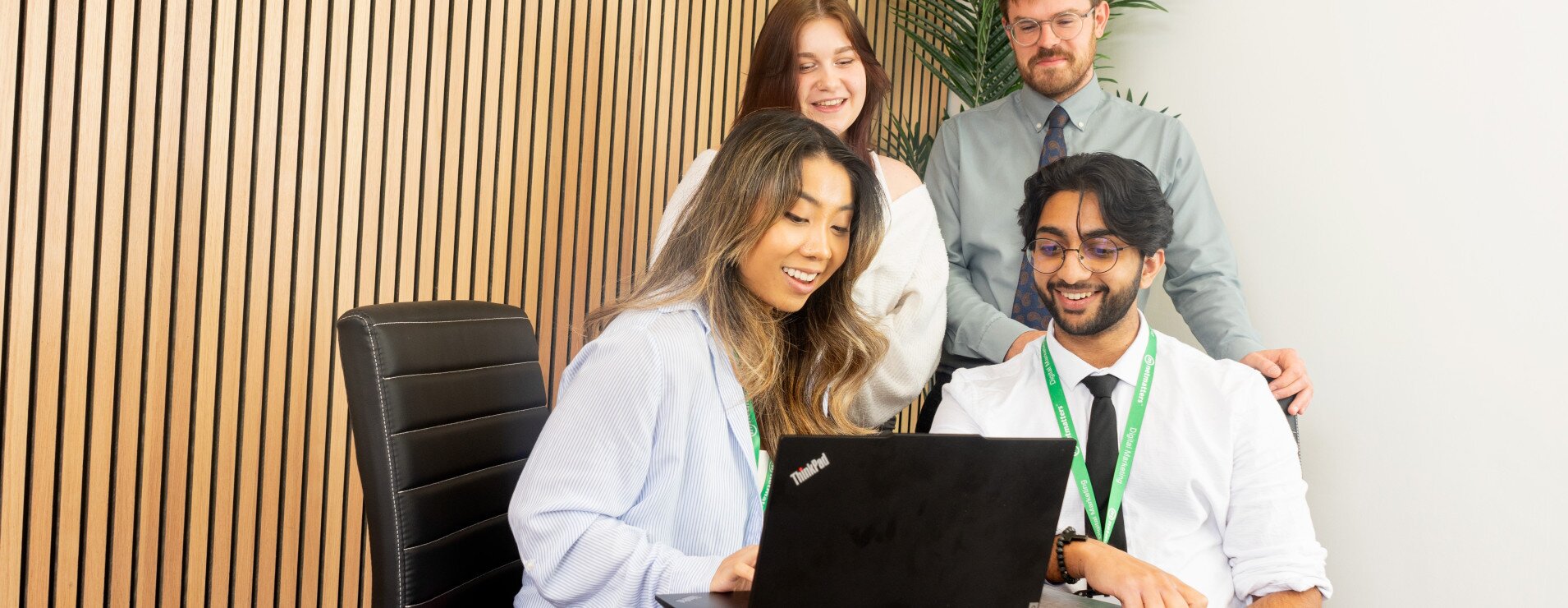 Team members sitting around a laptop.